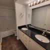 Renovated bathroom with double vanity w/ granite countertops and new bathtub and surround