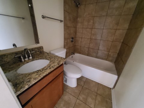 Renovated bathroom w/ new bathtub, surround and vanity with granite countertops
