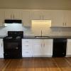 Renovated Kitchen with/ new white shaker cabinets, black granite counters, single pull Kohler faucet