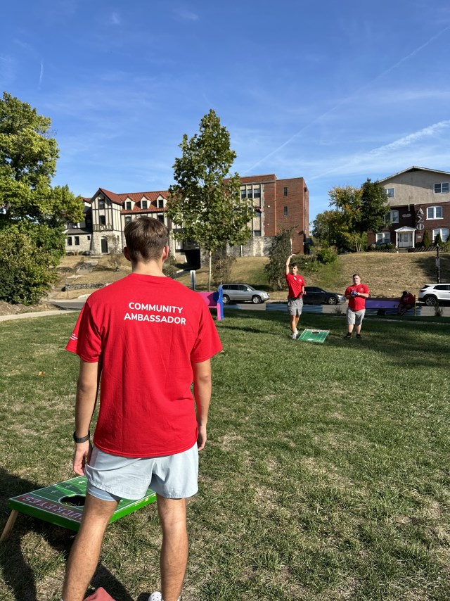 A Community Ambassador playing cornhole.