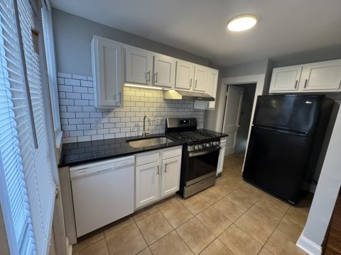 Renovated Kitchen with/ new white shaker cabinets, black granite counters, single pull Kohler faucet