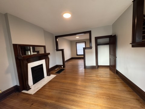 Living room w/ decorative fireplace and hardwood floors