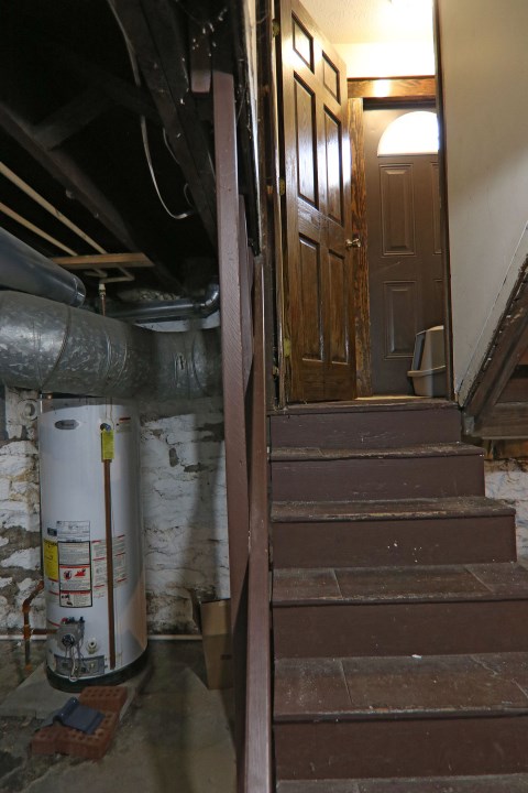 Going up from the basement with view of water heater