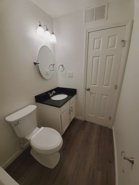 New vanity with granite, mirror, light fixture, and faucet