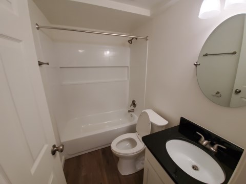 Renovated bathroom w/ new bathtub, surround and vanity with granite countertops