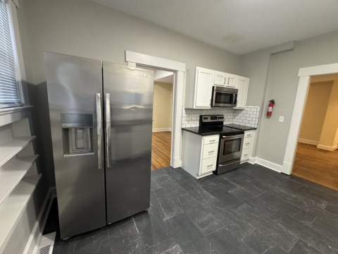 Kitchen w/ black marble floors and white subway backsplash