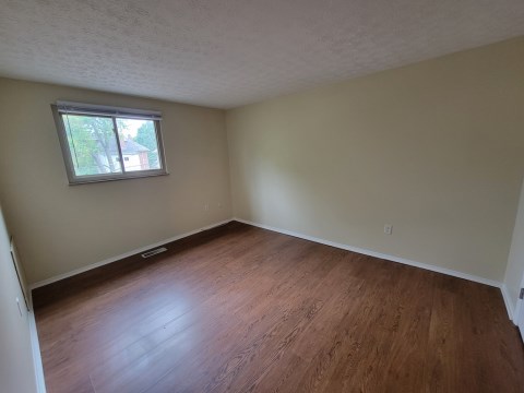 Large living room w/ window overlooking park