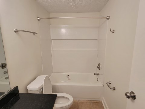 Renovated bathroom w/ new bathtub, surround and vanity with granite countertops