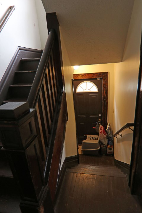 View of stairways to 2nd floor and basement with side exterior door