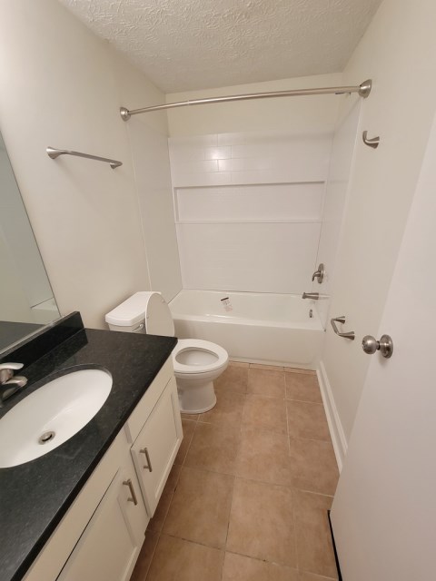 Renovated bathroom w/ new bathtub, surround and vanity with granite countertops