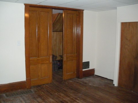 Front bedroom with original hardwood pocket doors