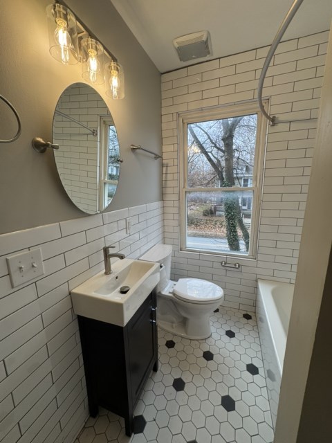 Renovated Bathroom w/ decorative tile, extra large bathtub, new toilet, new vanity and Moen/Kohler fixtures