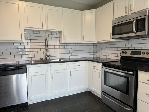 Renovated Kitchen w/ granite countertops subway tile back splash and stainless appliances