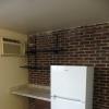 View of fridge/freezer, desk, and through wall air conditioner.